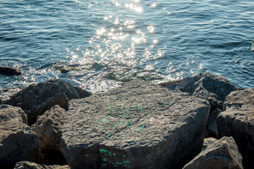 sea shining with sun rays in the rocky beach 