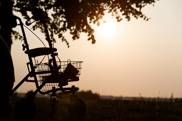 Fototapeta premium Silhouette of a stroller against a sunset in a serene outdoor setting