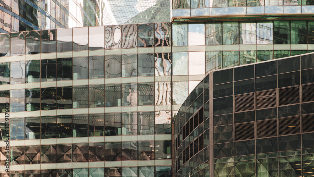 Poster A tall building with many windows and a reflection of the sky. The building is made of glass and has a modern design