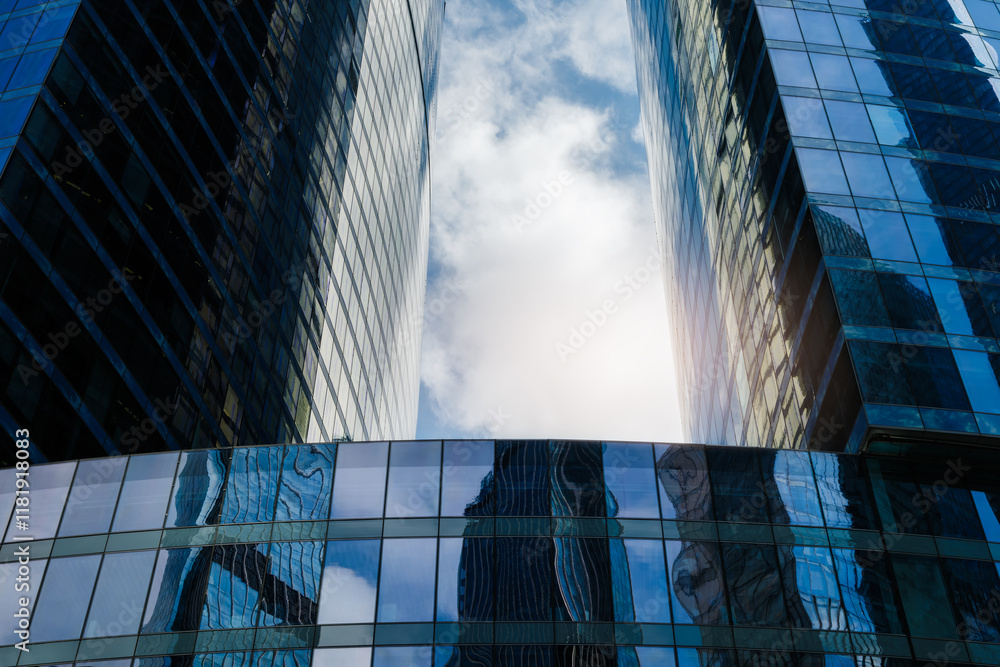 Aufkleber two tall buildings with many windows reflecting the sunlight. the buildings are surrounded by a clea