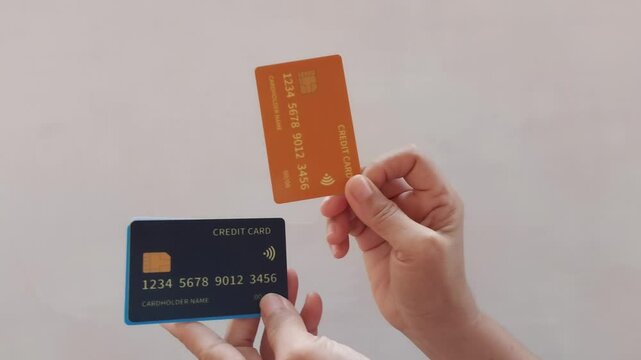 A man holds six colorful credit cards. The cards are maroon, orange, green, blue, white, and black.