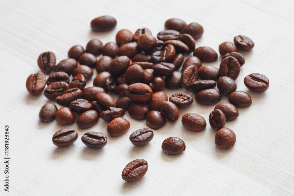 Poster A pile of coffee beans on a white surface. The beans are of different sizes and shapes, and they are spread out in a random pattern. Concept of abundance and variety