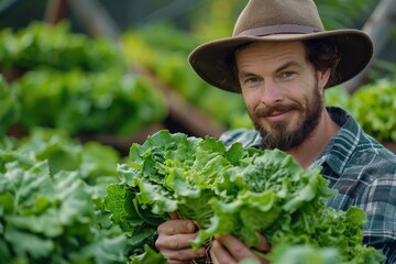 A smiling man in a hat holds fresh lettuce in a lush green farm, showcasing the joy of organic farming and harvest.