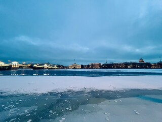 Fototapeta premium Iced city river, winter city riverside at the twilights, ice on the river, night sky, illumination 
