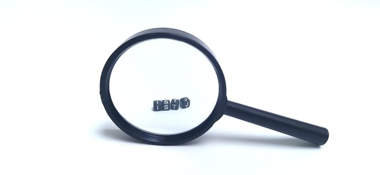 Small black plastic cubes with ISTJ letters, through a magnifying glass. ISTJ is one of the 16 personality types identified by the Myers-Briggs Type Indicator or MBTI. Concept of psychology. 