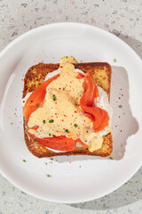 Portion of brioche breakfast toast with egg and salmon