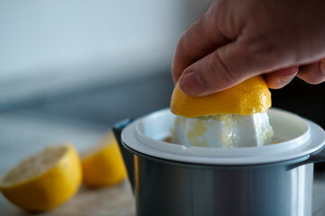 Chef squeezing fresh lemon juice with manual citrus juicer