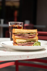 Side view on gourmet brisket sandwich with a glass of soda drink