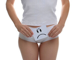 STD (sexually transmitted disease). Woman holding sticky note with drawn sad face on white...