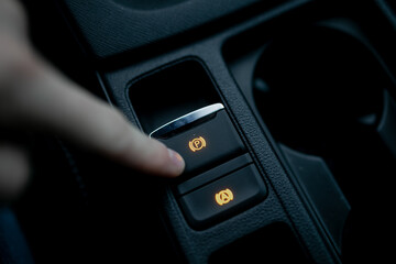 Car driver using fingers pushing electronic parking brake (EPB) in modern car for braking system