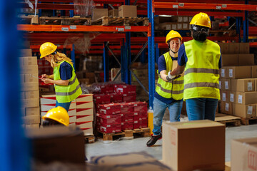 Warehouse worker with Down syndrome handing a box to his coworker