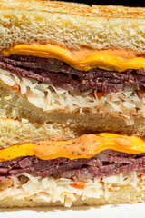 Closeup on cut brisket sandwich with cabbage and cheese