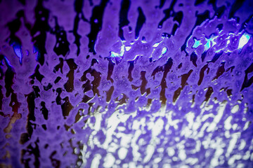 Industrial washing carwash shampoo solution foam close up in blue and purple coloring