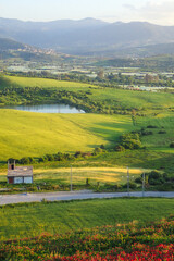 Naklejka premium African countryside, Spring day landscape of fields, meadows and hills with mountains in the background and blue sky with clouds, Algerian and a lake in the Algerian countryside, rural Jijel Algeria.