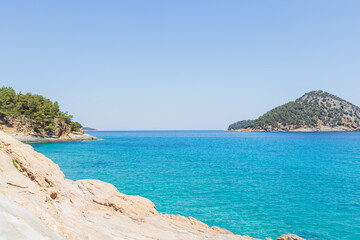 Obraz premium Breathtaking view of the crystal-clear turquoise waters of the Aegean Sea, with lush green islands in the distance.