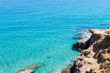 Crystal Clear Turquoise Sea Waters Along the Rocky Coastline at Summer Day