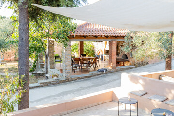 Obraz premium Serene outdoor space with a stone patio, a covered dining area, and lush greenery.