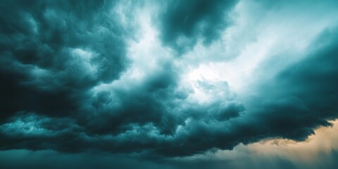 Obraz premium Aerial view showcasing dark sky clouds in the background. The dark gray storm clouds emerge before the storm, illustrating the beautiful yet intense nature of storm clouds during the day.