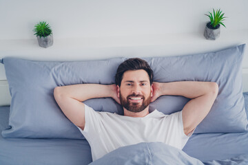 Photo of funky happy mature guy sleepwear pajama lying bed arms behind head indoors home house...