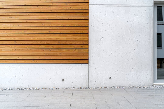 Modern facade featuring light textured concrete wall and wooden slats, creating stylish and contemporary look. design emphasizes simplicity and elegance in architecture