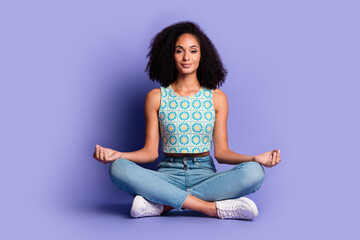 Young woman meditating in trendy summer top against a purple background, showcasing a peaceful...
