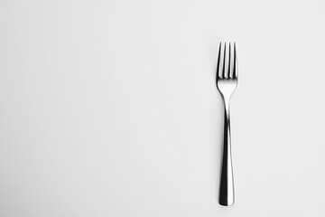 This sleek metal fork rests on a pristine white background, highlighting its minimalist form and function beautifully.