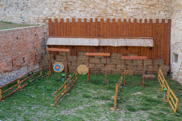 Archery range in a historical setting with wooden targets and straw bales, perfect for outdoor...