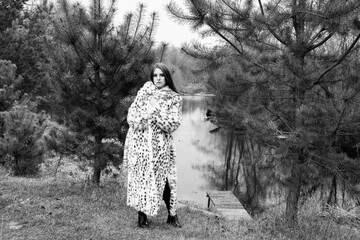 Portrait of a young beautiful dark-haired girl in an autumn-spring forest.