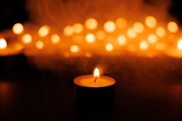 Holy glowing candlelight with soft background candles on black