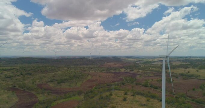 Forward tracking drone view of  Wind Turbines On Green Hills at wind farm, Queensland, Australia