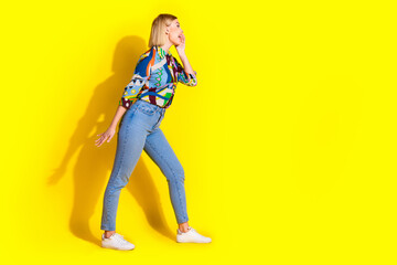 Full size photo of pretty young girl scream empty space wear trendy colorful outfit isolated on yellow color background