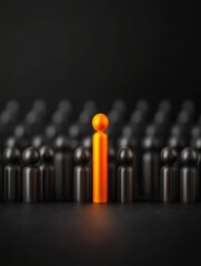 One Orange Figure Stands Out - A single orange figure stands apart from a crowd of black figures, symbolizing individuality, leadership, difference, uniqueness, and standing out.
