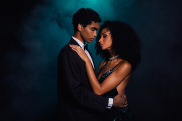 Elegant couple embracing in glamorous attire against a moody green and black casino backdrop