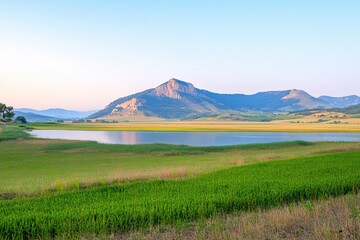 Fototapeta premium Serene Landscape with Lake, Mountains, and Lush Green Fields at Sunrise in Nature