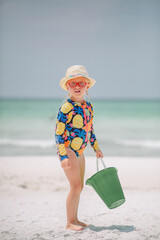 little girl on the beach with a bucket