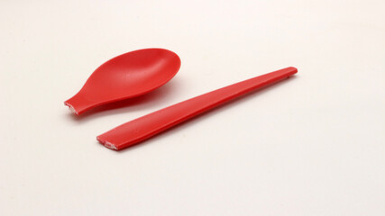 Broken red plastic spoon isolated