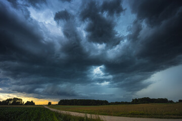 Dramatic storm clouds over wheat field, creating threatening atmosphere in countryside