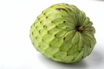 Fototapeta premium Whole Green Cherimoya Fruit on White Surface