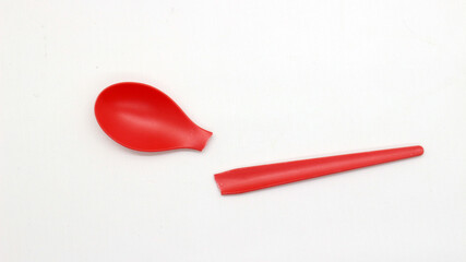 Broken red plastic spoon isolated