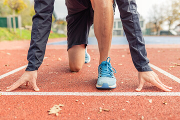 Close up of men on track at arena for speed challenge. Male athlete ready for running at stadium....