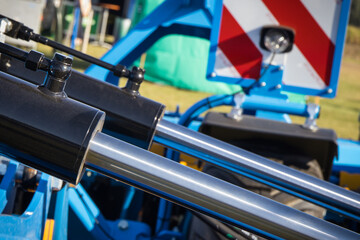 Black pistons or actuators in blue pneumatic or hydraulic machine. Technology