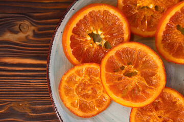 candied orange slices on wooden background, homemade candied fruits top view