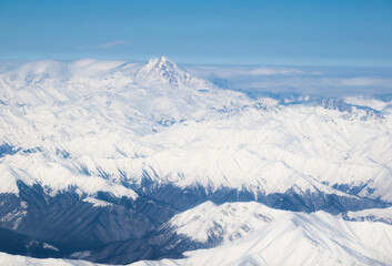 Naklejka premium Beautiful airplane view of Mount Kazbek and the Caucasus Mountains on a sunny winter day