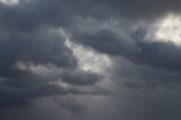 Thick gray clouds have completely covered the sky before the rain.