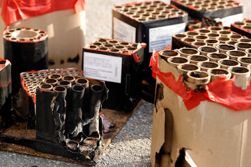 Batteries with fired fireworks on street in sunlight, trash from spent fireworks on New Year's Day, environmental impact from disposal costs and cleanup