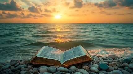 Open bible on pebble beach at sunset.