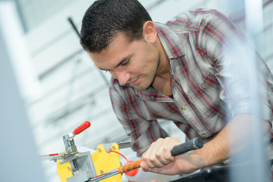 technician fixing a metal bar