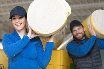 caucasian construction workers with roll of insulating material