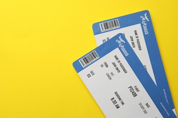Travel agency. Flight tickets on yellow background, top view. Space for text