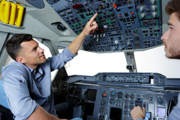 two men in modern flight simulator for pilot training